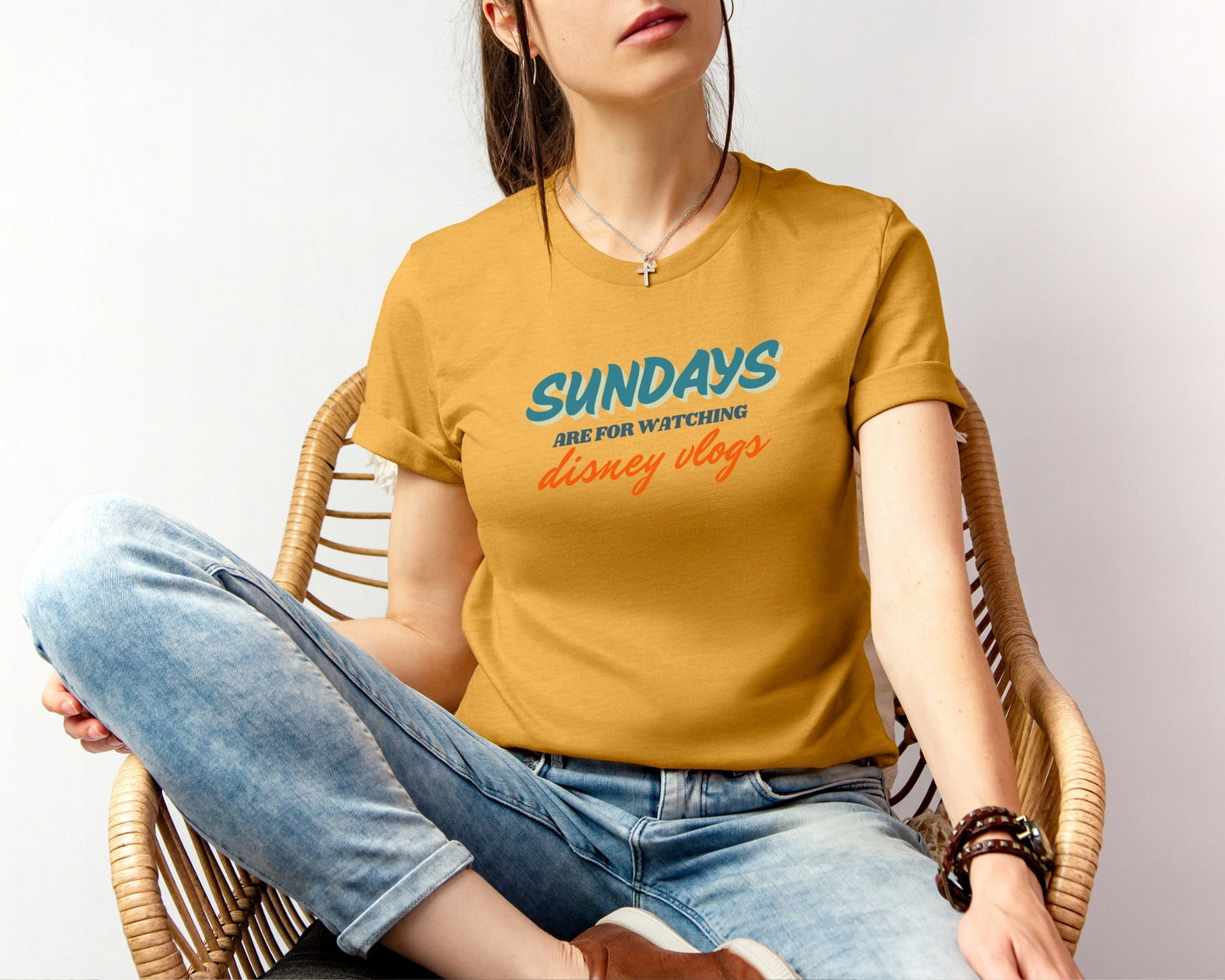 female model wearing bella and canvas 3001 in mustard with 'sundays are for watching Disney vlogs' print on chest inspired by Disney YouTube