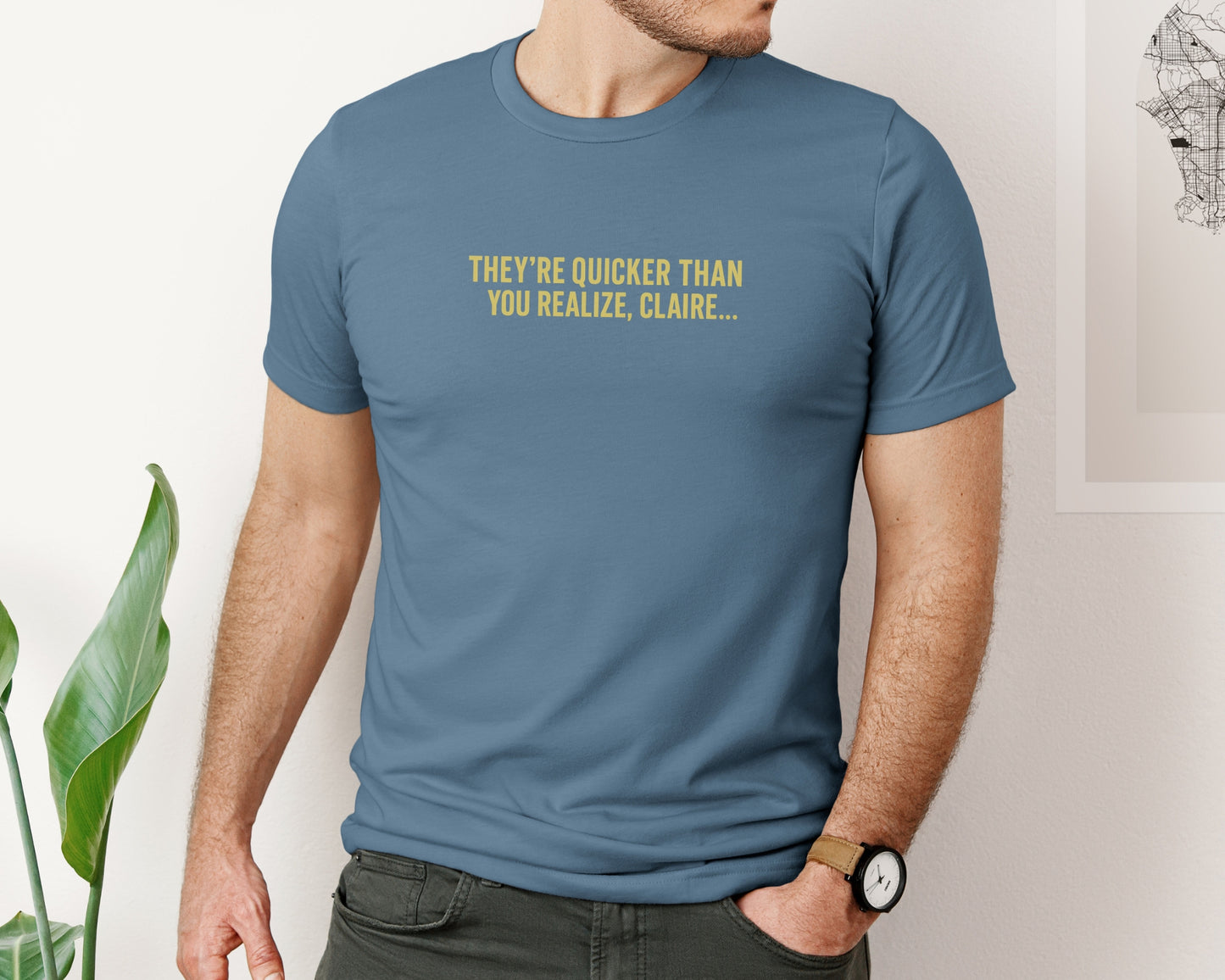 Male model wearing Bella and Canvas 3001 in steel blue with velocicoaster universal inspired 'they're quicker than you realise Claire' print on chest 