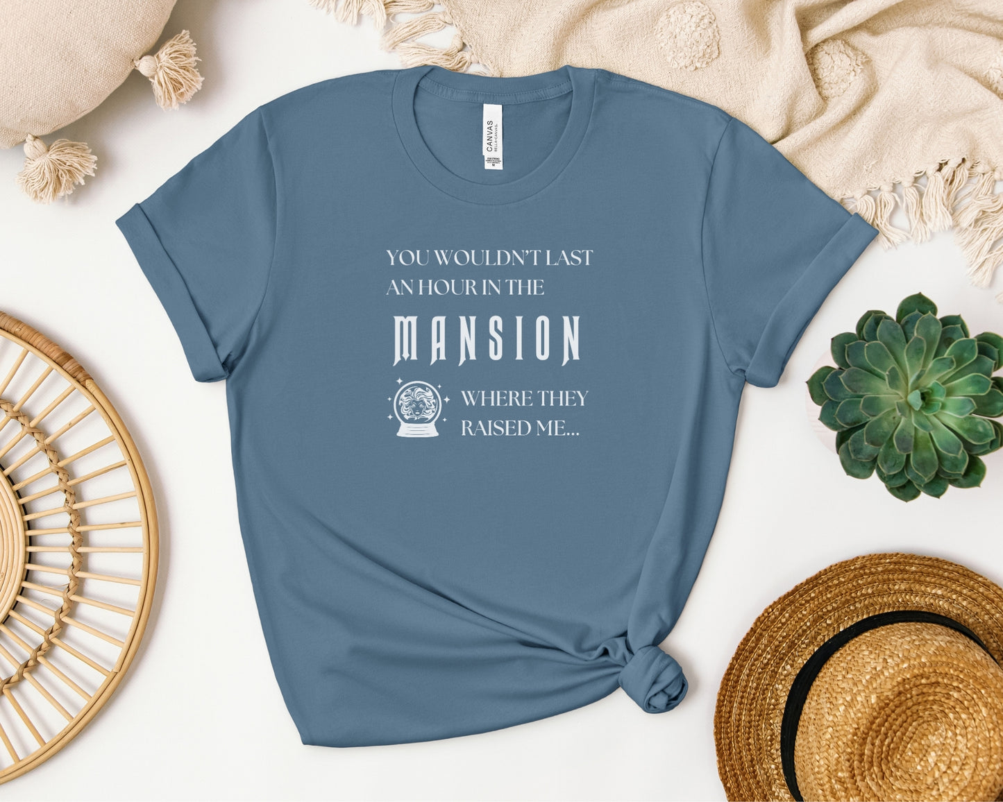 bella and canvas 3001 t-shirt in steel blue laid flat with 'you wouldn't last an hour in the mansion where they raised me' on chest, TTPD taylor swift x haunted mansion inspired design 