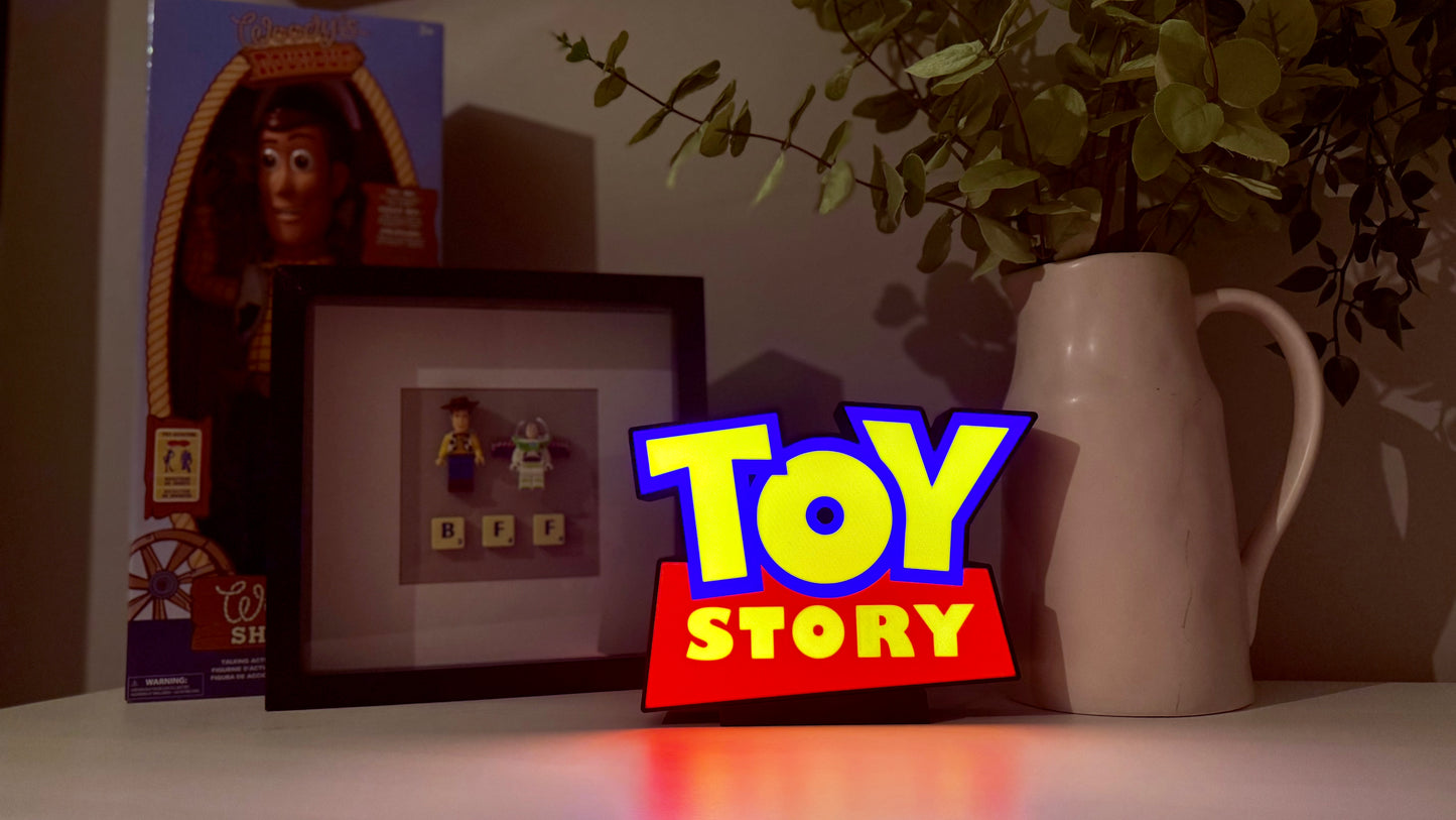 Toy Story-themed decor with a 'Toy Story' sign, framed picture, and plant on a shelf.