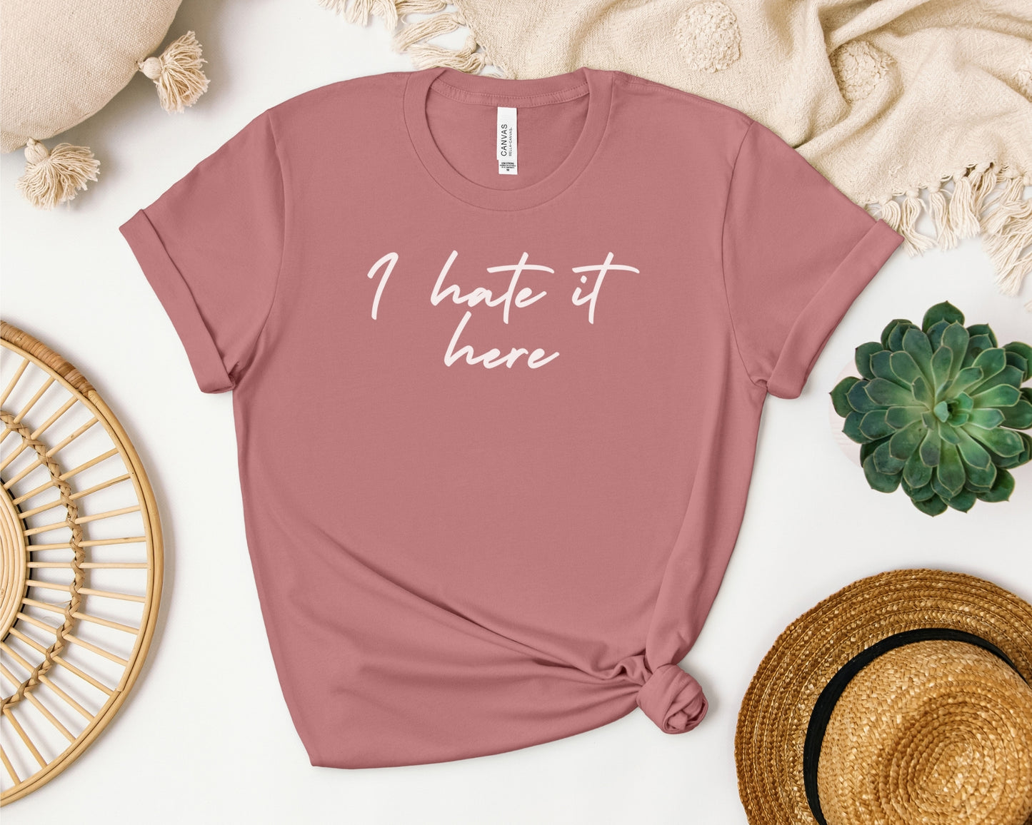 Bella and Canvas 3001 t-shirt in mauve laid flat with TTPD lyric design on chest, 'I hate it here' print on chest inspired by Taylor Swift