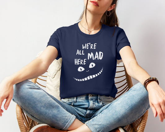 female model wearing bella and canvas 3001 t-shirt in navy with 'we're all mad here' cheshire cat inspired print on chest